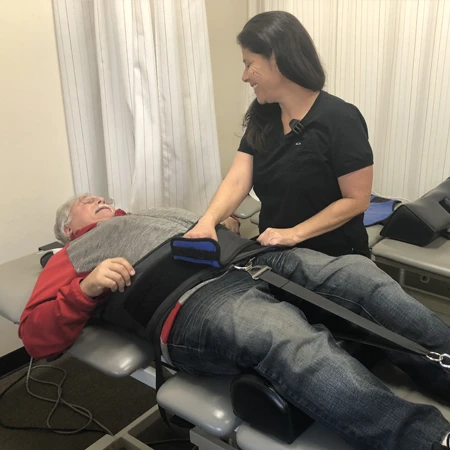 A patient being strapped into a spinal decompression table