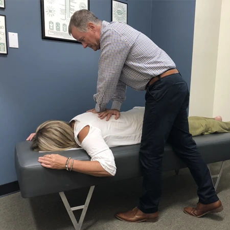 Dr. Barry Canty adjusting a patient's upper back