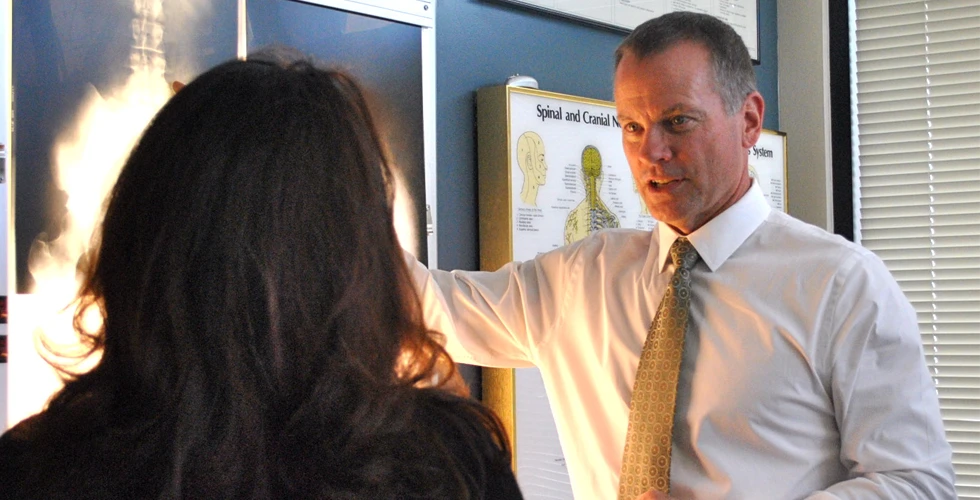 Dr. Barry Canty examining a patient's x-rays and discussing treatment plan with her
